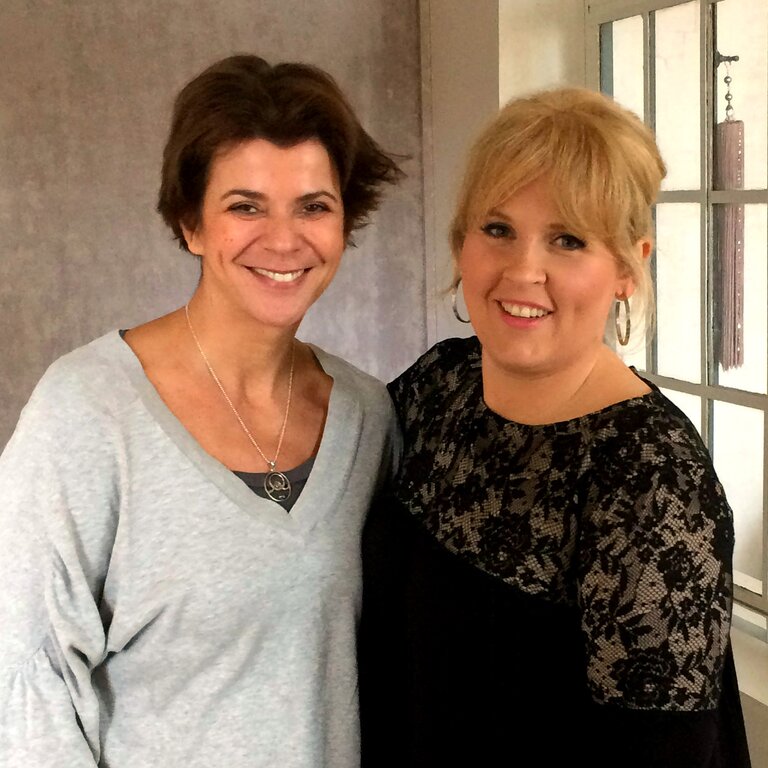 Zwei lächelnde Frauen – eine davon Schlagersängerin Maite Kelly – stehen nebeneinander und blicken in die Kamera. | © Claudia Kirschner