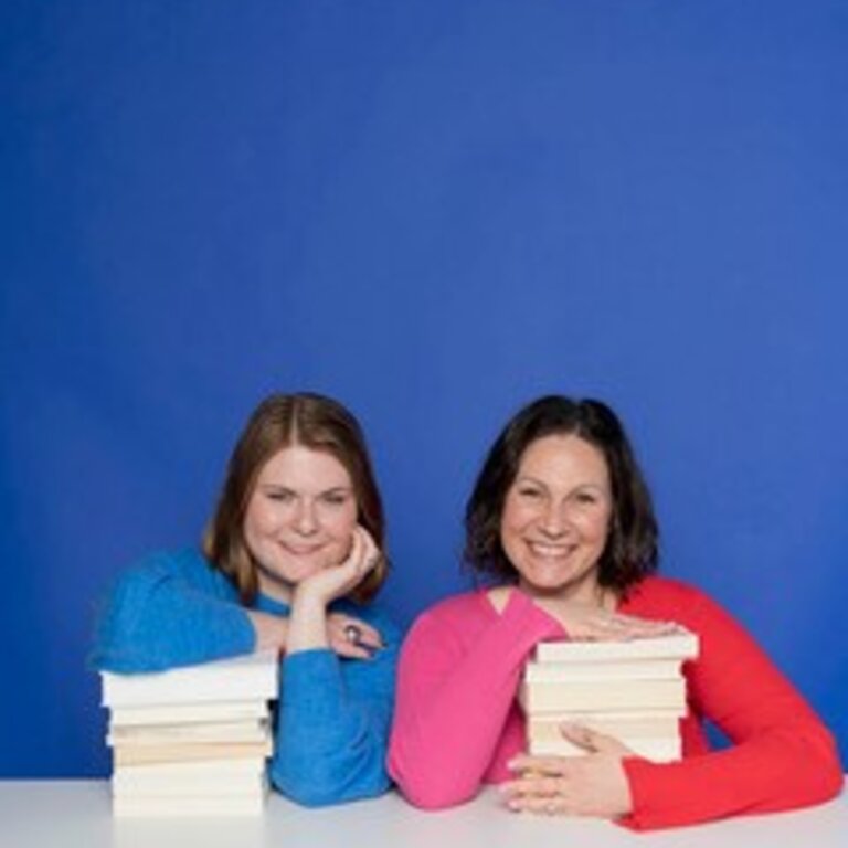 Zwei Frauen mit Büchern sitzen vor einem blauen Hintergrund. | © Ulrike Schacht