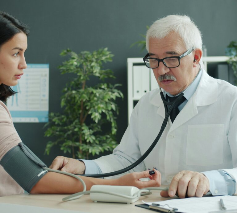 Ein männlicher Arzt misst den Puls einer weiblichen Patietin. | © Vitaly Gariev | Unsplash