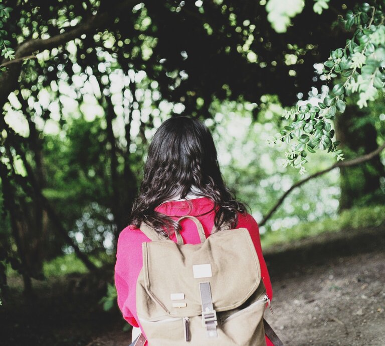 Schulkind mit Rucksack, pinke Jacke, Blick von Kamera weggerichtet.  | © Florencia Viadana | Unsplash 
