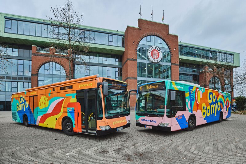Der originale GoBanyo Duschbus und sein Nachfolger stehen zueinander gewendet vor dem FC St. Pauli Millerntorstadion | © Der originale GoBanyo-Duschbus (links) und sein Nachfolger | Bild: Julia Schwendner