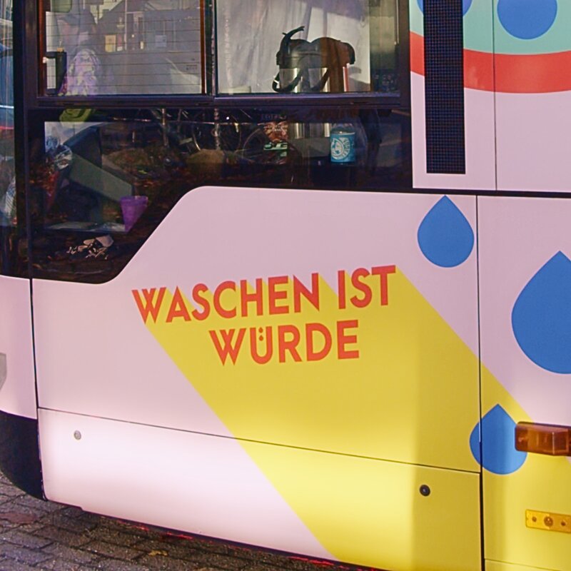 Auf dem GoBanyo Duschbus unter dem Seitenfensters des*der Busfahrer*in steht "Waschen ist Würde". | © "Waschen ist Würde." Bild: Fabia Suhl