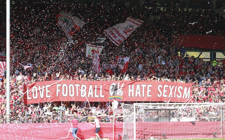 Stadion voller Fans, auf einem riesigen Plakat steht: Love Football, Hate Sexism | © IMAGO / Sportnah