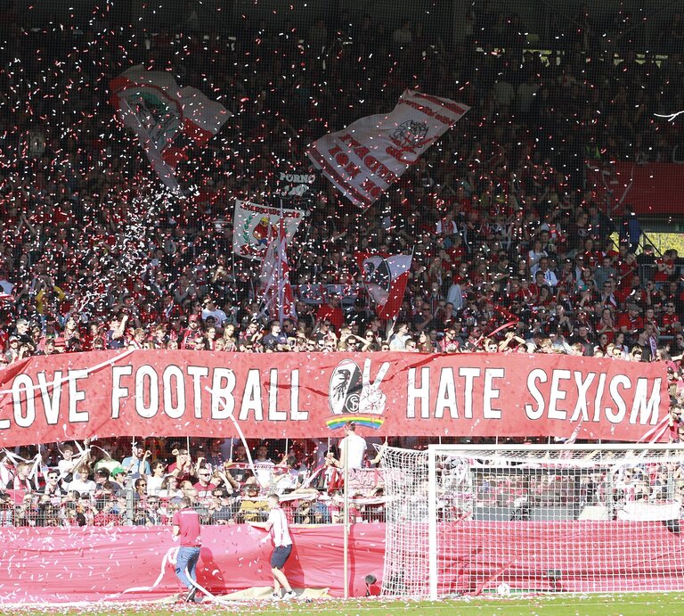 Stadion voller Fans, auf einem riesigen Plakat steht: Love Football, Hate Sexism | © IMAGO / Sportnah