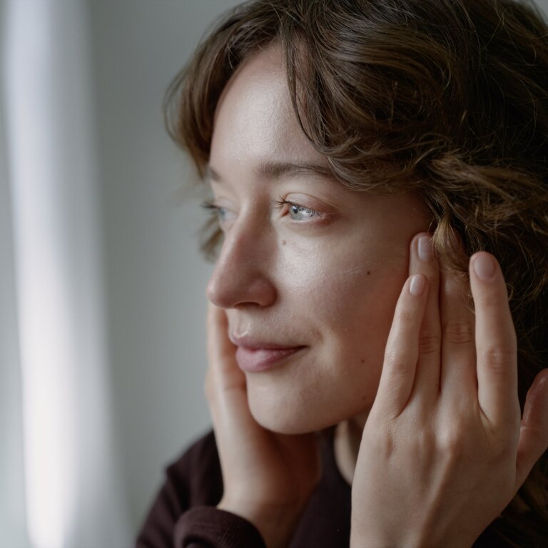 Junge Frau nutzt die Gesichtscreme Rose von Dr. Hauschka.  | © Dr. Hauschka | Dedicated to you.