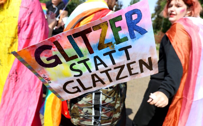 Demoschild: "Glitzer statt Glatz" | © IMAGO / Müller-Stauffenberg