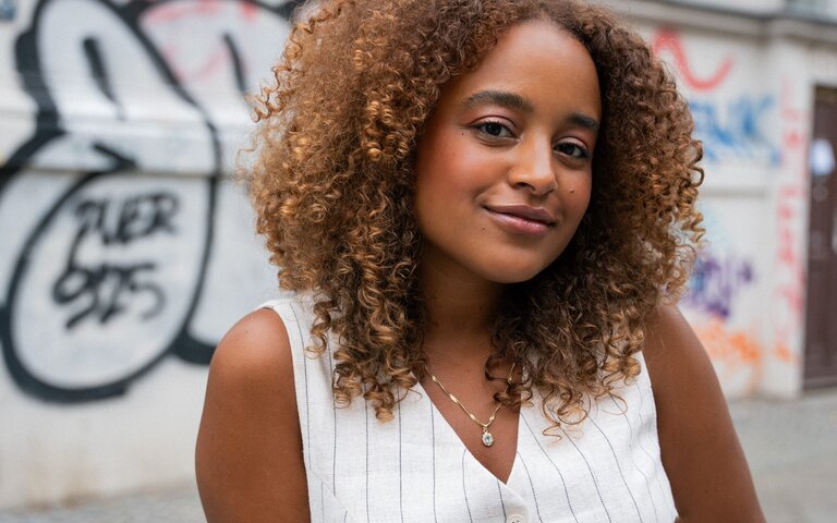 Foto von der Autorin Gizem Eza, die vor einer Hauswand steht. | © Die Autorin Gizem Eza kritisiert, dass Diversität wie ein Trend behandelt wird. Foto: Gideon Böhm 