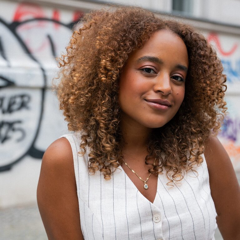 Foto von der Autorin Gizem Eza, die vor einer Hauswand steht. | © Die Autorin Gizem Eza kritisiert, dass Diversität wie ein Trend behandelt wird. Foto: Gideon Böhm 