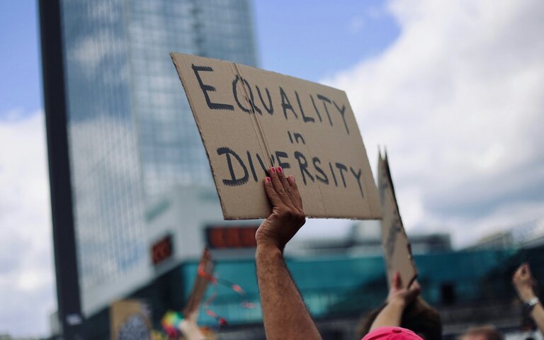 Equality in Diversity steht auf dem Schild, das ein*e Demonstrationsteilnehmer*in in die Luft hält. | © Foto: Amy Elting | Unsplash