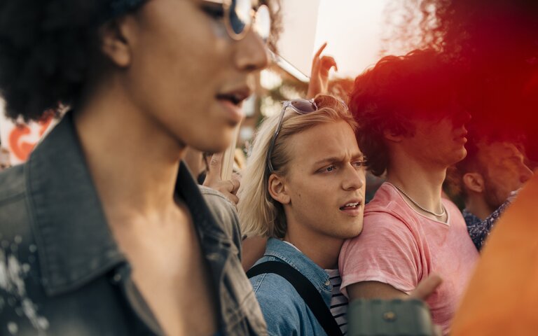 Gruppen von Menschen, die eng zusammensteht und Rufe von sich gibt. | © Foto: Youssef Naddam | Getty Images 