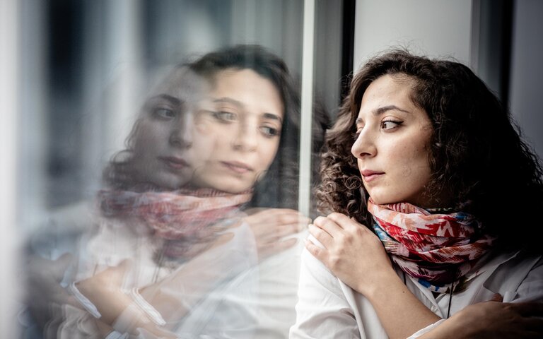 Die Journalistin Heba Alkadri blickt gedankenverloren aus dem Fenster. Ihr Gesicht spiegelt sich in der Scheibe. | © Bild: FUNKE Foto Services | André Hirtz
