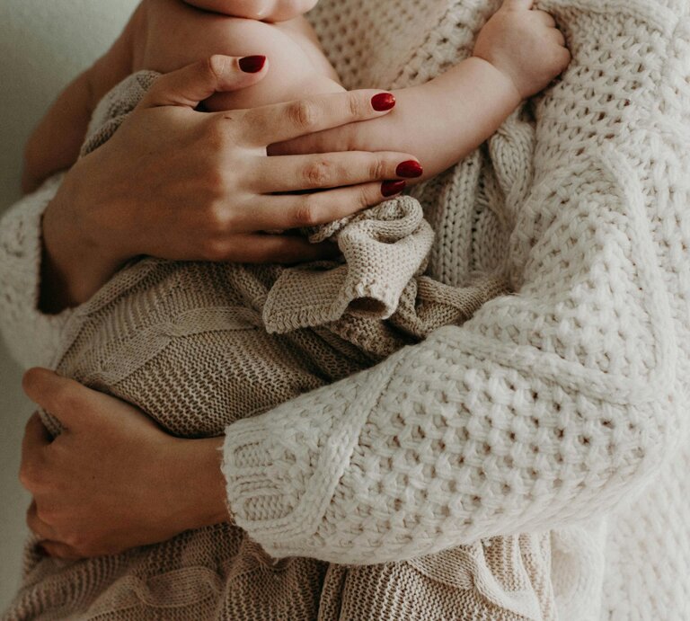 Mutter hält ihr Kind im Arm | © Foto: Kristina Paukshtite | Pexels