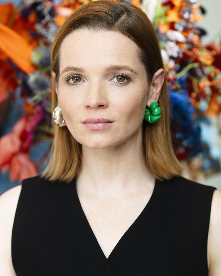 Karoline Herfurth in schwarzer Weste vor einem großen Blumenstrauß | © Karoline Herfurth